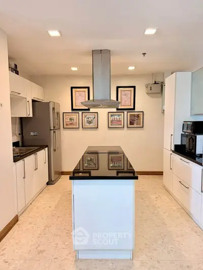 Modern kitchen with sleek island and stainless steel appliances in a stylish home.