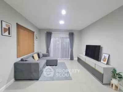 Modern living room with sleek furniture and large window for natural light.