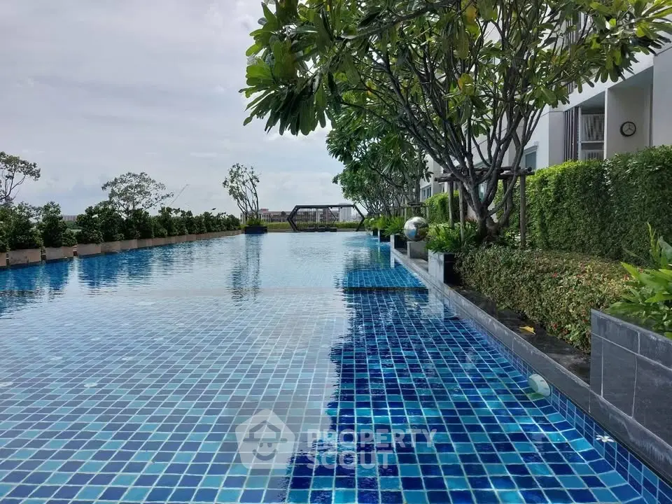 Luxurious infinity pool with lush greenery and modern design in a high-end residential complex.