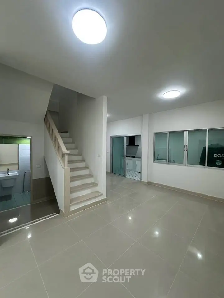 Spacious modern interior with staircase and tiled flooring, ideal for family living.