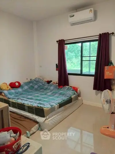 Cozy bedroom with air conditioning and window view, perfect for relaxation and comfort.