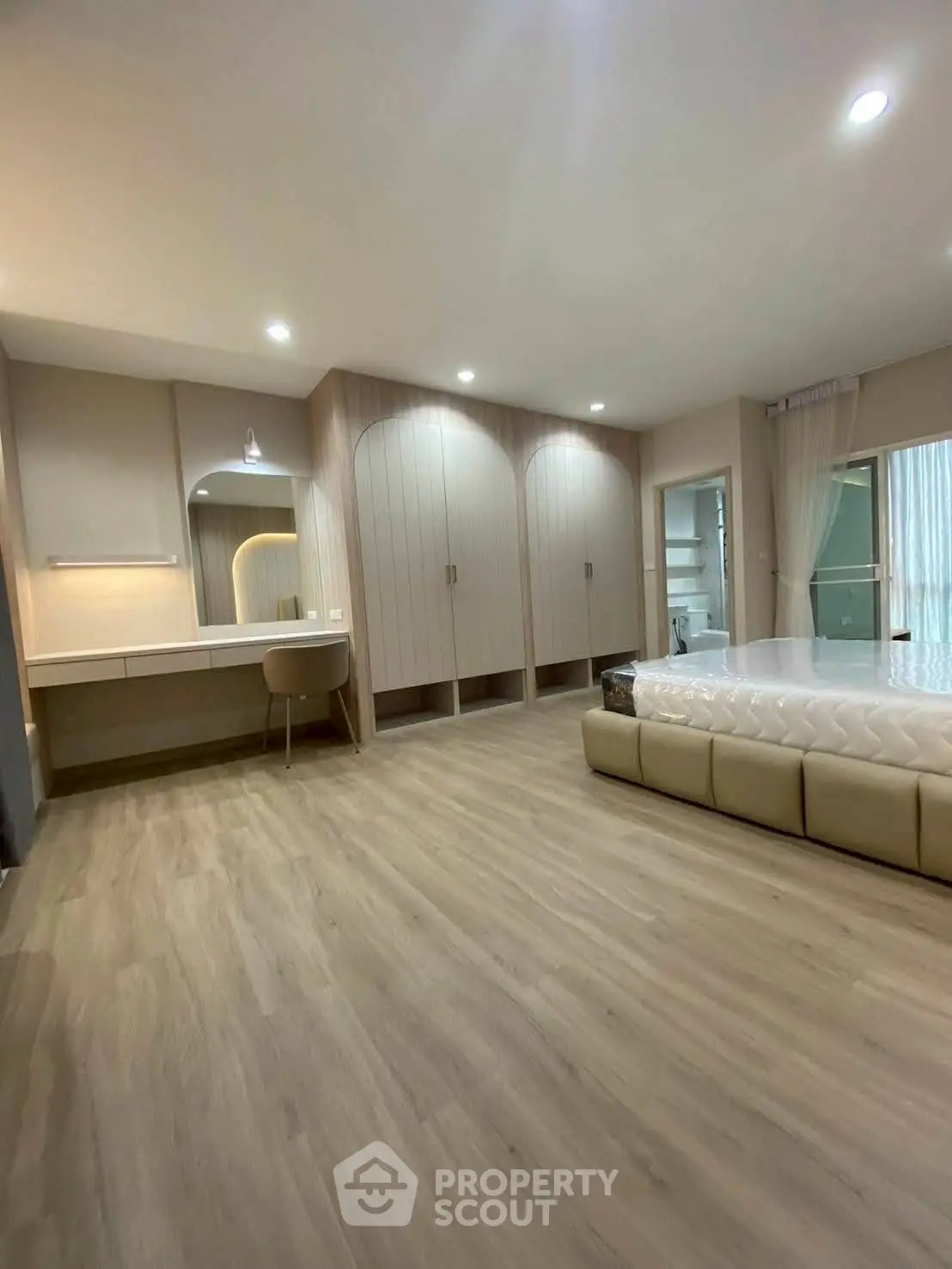 Spacious modern bedroom with elegant wood flooring and built-in wardrobe