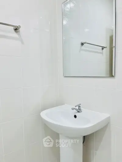 Modern bathroom with sleek white sink and mirror, perfect for minimalist design lovers.