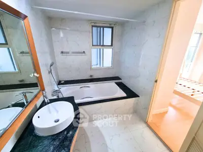 Spacious bathroom with modern bathtub and elegant marble finish