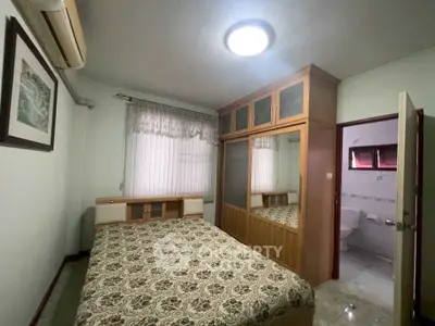 Cozy bedroom with built-in wardrobe and patterned bedding