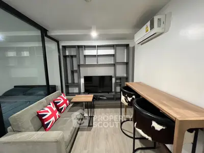 Modern living room with stylish decor and open layout, featuring a cozy sofa and sleek shelving unit.