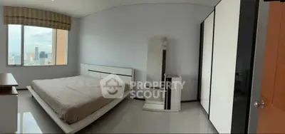 Spacious modern bedroom with city view and sleek furnishings