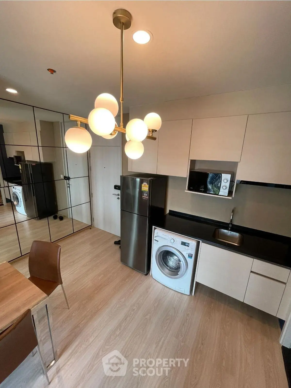 Modern kitchen with sleek appliances and stylish lighting in a contemporary apartment.