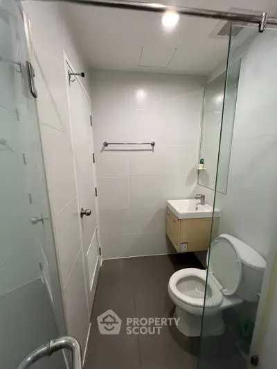 Modern minimalist bathroom with glass shower and sleek fixtures, perfect for contemporary living.