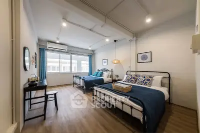 Spacious bedroom with twin beds and modern decor in a bright apartment