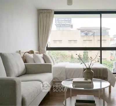 Modern living room with cozy sofa and large window offering city view