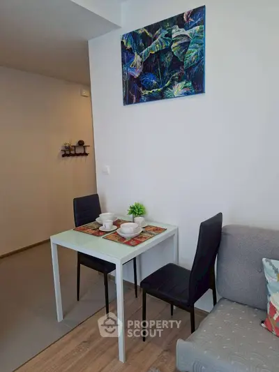 Cozy dining area with modern decor and vibrant artwork in a stylish apartment.