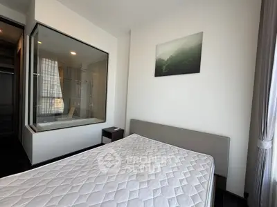 Modern bedroom with large window and built-in bathtub, offering a sleek and minimalist design.