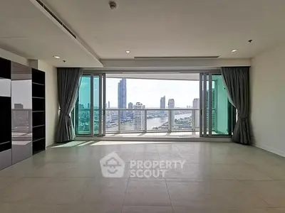 Spacious living room with panoramic city view and large windows in modern high-rise apartment.