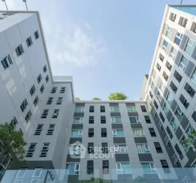 Modern apartment building exterior with sleek design and large windows, showcasing urban living.