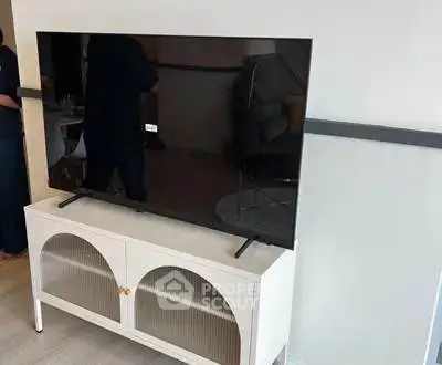 Modern living room with sleek TV on stylish cabinet, perfect for entertainment.