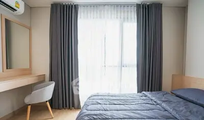 Modern bedroom with sleek design, featuring a cozy bed and stylish curtains.