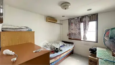 Cozy bedroom with natural light, air conditioning, and simple furnishings, ideal for comfortable living.