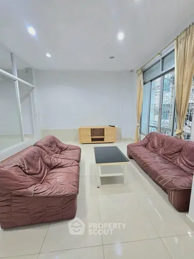 Spacious living room with modern sofas and large windows for natural light.