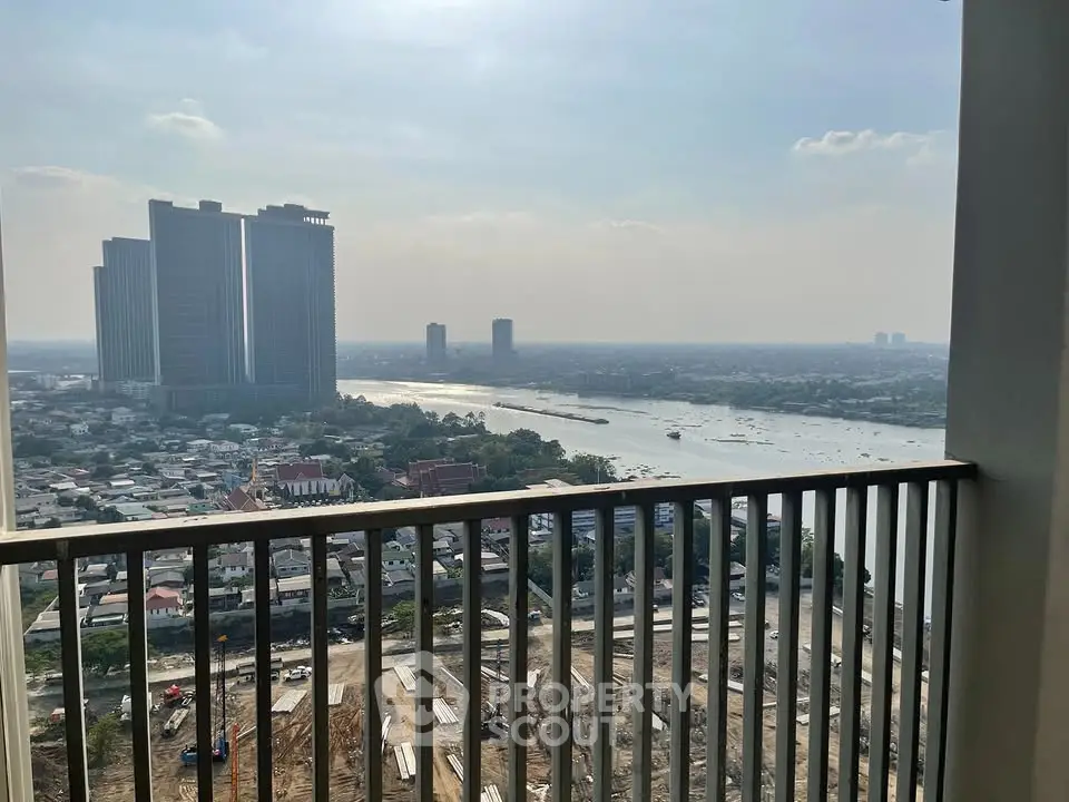 Stunning high-rise balcony view overlooking river and cityscape, perfect for urban living enthusiasts.