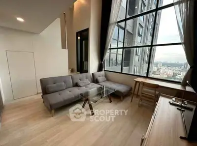 Modern living room with large windows and city view in high-rise apartment