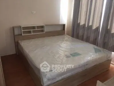 Spacious bedroom with new wooden bed frame and large windows for natural light.