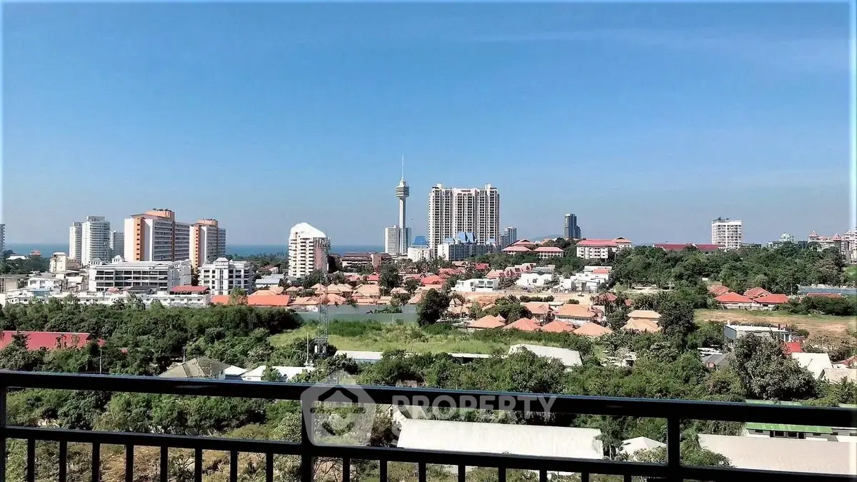 Stunning cityscape view from a high-rise balcony overlooking urban skyline and lush greenery.