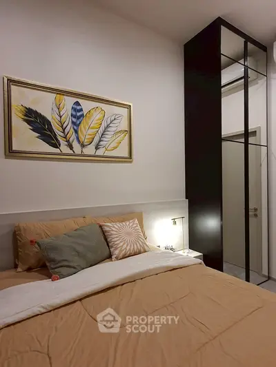 Cozy bedroom with modern decor and stylish artwork above the bed.