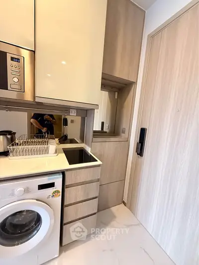 Modern compact kitchen with built-in appliances and sleek cabinetry