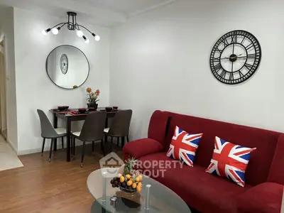 Chic living room with modern decor and dining area, featuring stylish lighting and vibrant accents.