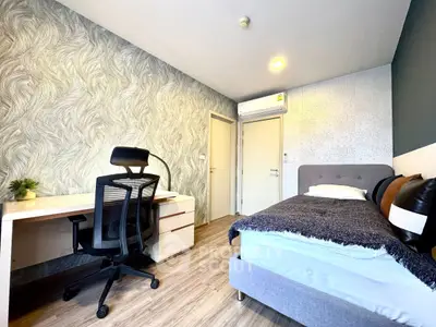 Modern bedroom with stylish decor, featuring a cozy bed, sleek desk, and comfortable chair, perfect for relaxation and work.