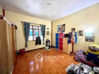 Spacious bedroom with wooden flooring and ample natural light