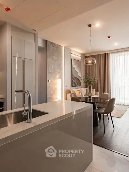 Modern open-plan kitchen and living room with elegant decor and natural light.