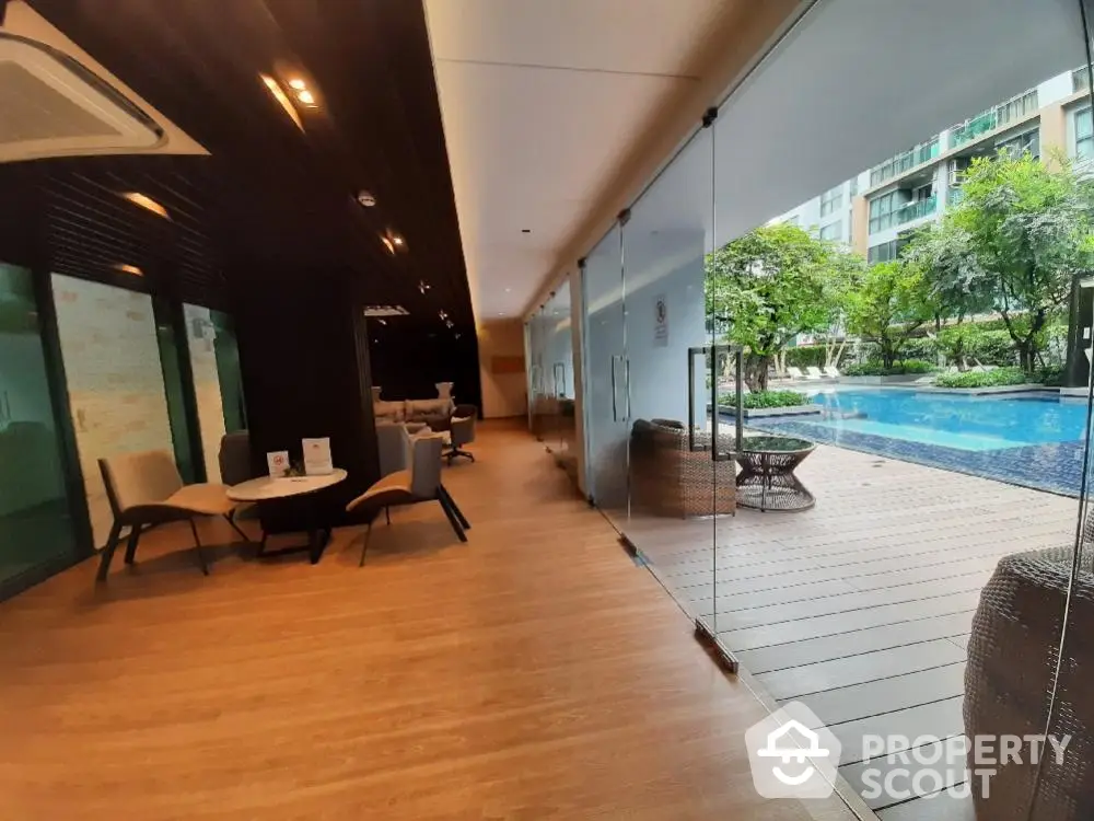 Luxurious poolside view with modern seating area and glass walls