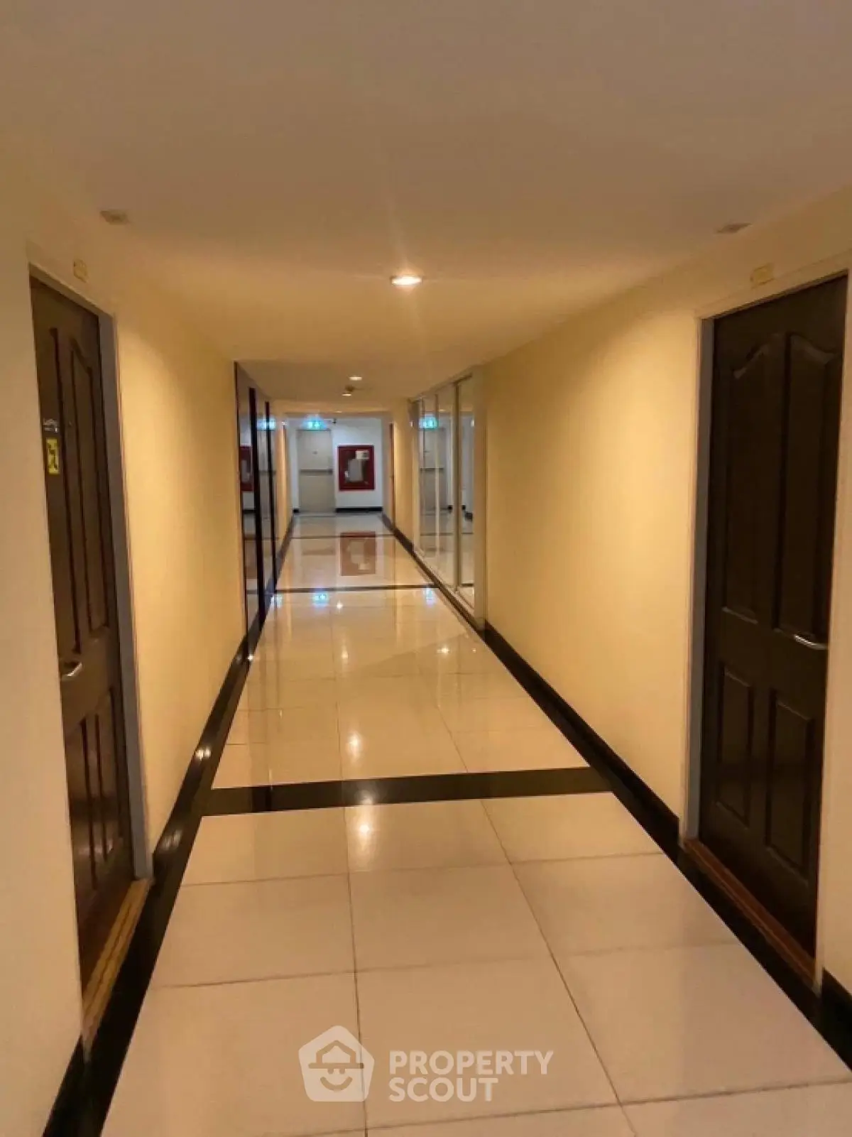 Spacious hallway with polished tile flooring and multiple doors in modern building