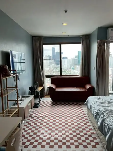 Modern living room with city view, stylish decor, and cozy seating area.