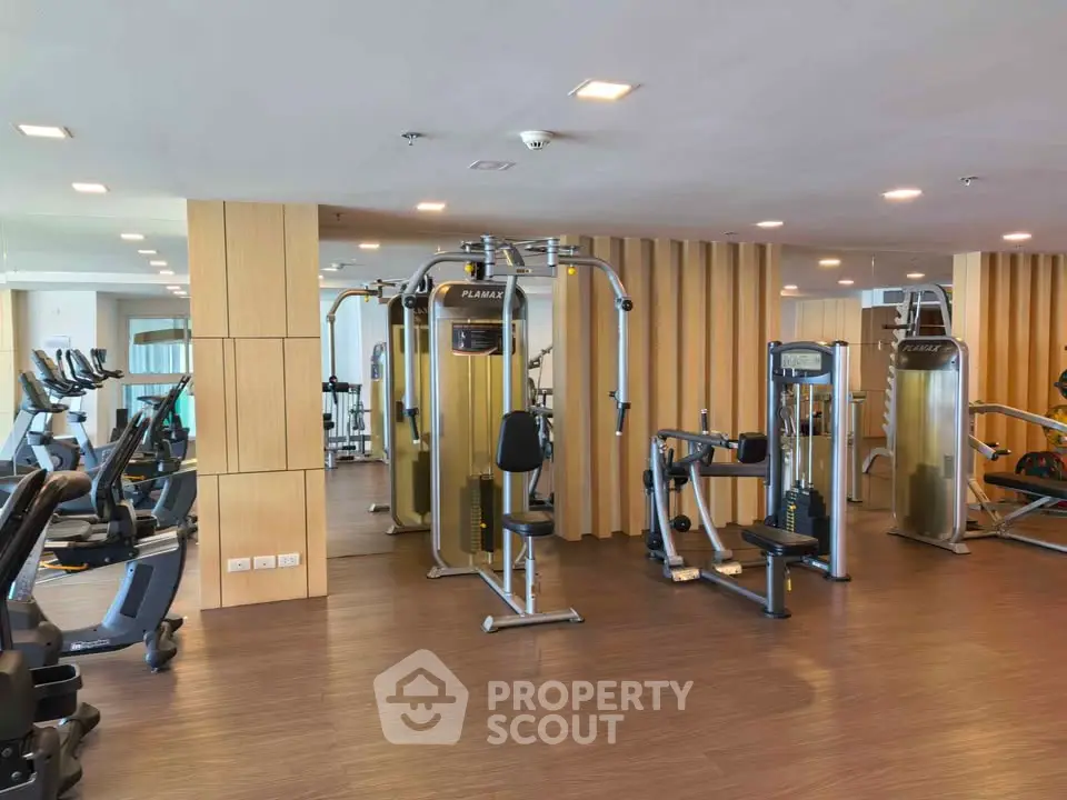 Modern gym with state-of-the-art fitness equipment and sleek wooden flooring.