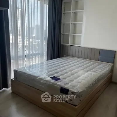 Modern bedroom with large window and stylish bed frame, perfect for urban living.