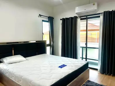 Spacious bedroom with modern decor and large windows for natural light.