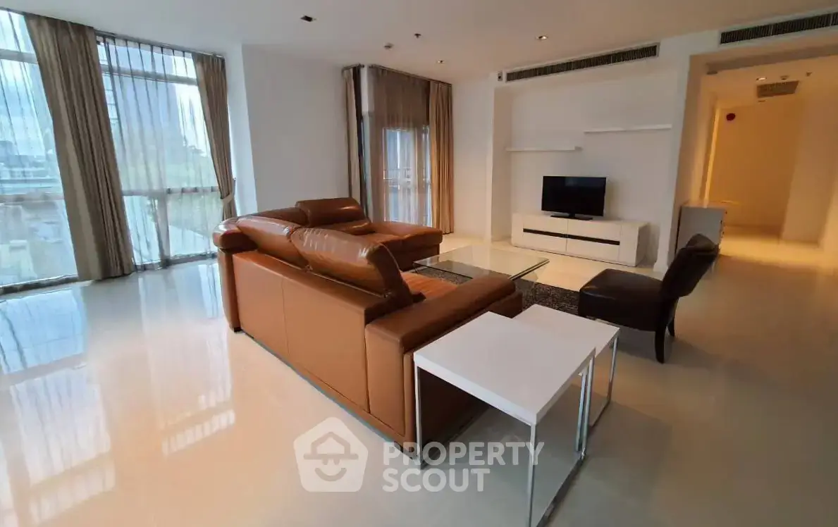 Spacious modern living room with leather sofa and large windows