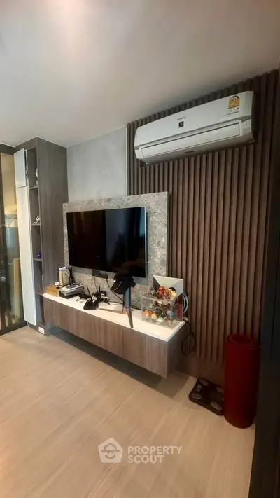 Modern living room with wall-mounted TV and air conditioning unit