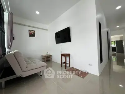 Modern living room with sleek design, featuring a wall-mounted TV and stylish furniture, perfect for relaxation.