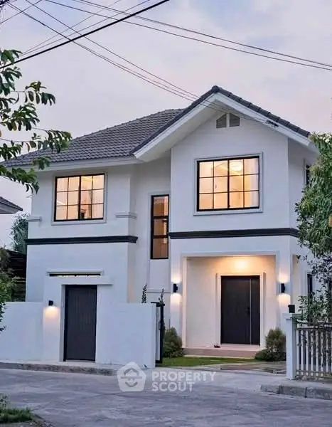 Charming modern two-story house with elegant facade and warm lighting, perfect for family living.