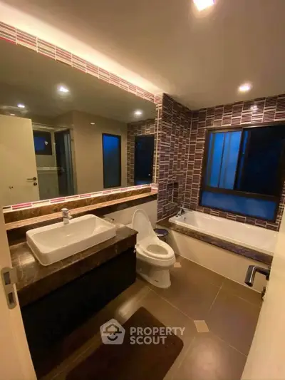 Modern bathroom with stylish tiles and bathtub in a contemporary home.
