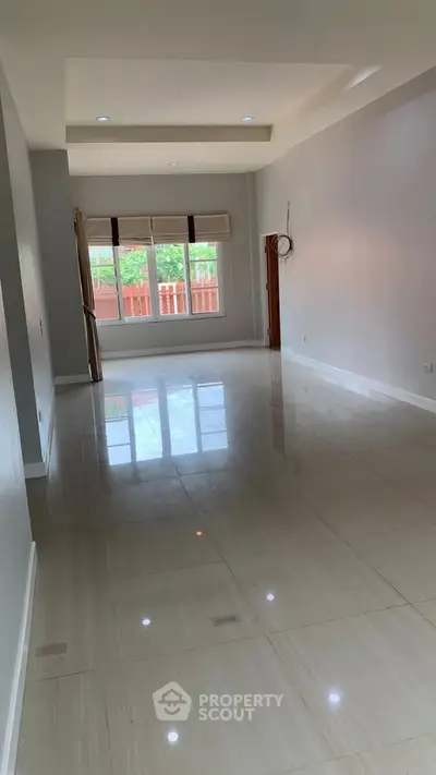 Spacious empty room with glossy tiled floor and large window view