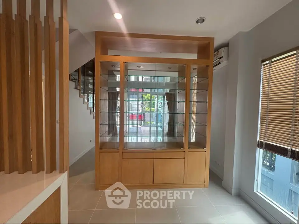 Spacious interior with wooden shelving and large windows, perfect for modern living.