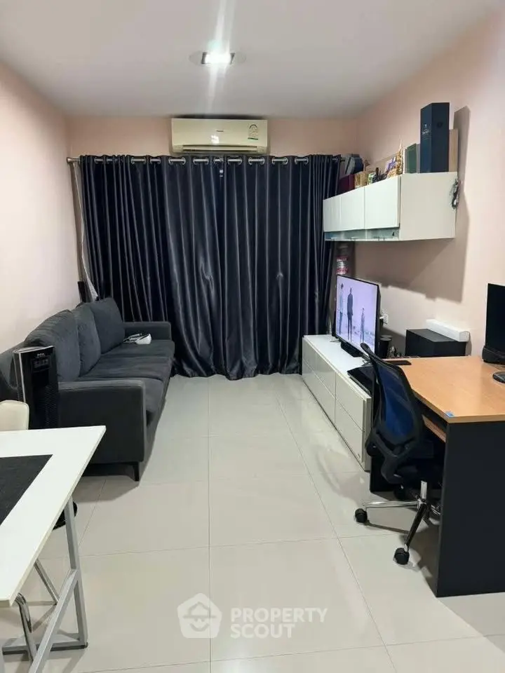 Modern living room with sleek furniture and large TV, perfect for relaxation and entertainment.