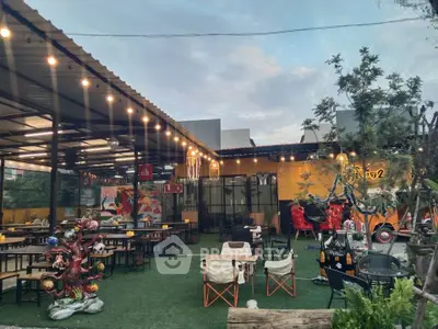 Charming outdoor dining area with string lights and eclectic decor, perfect for social gatherings.