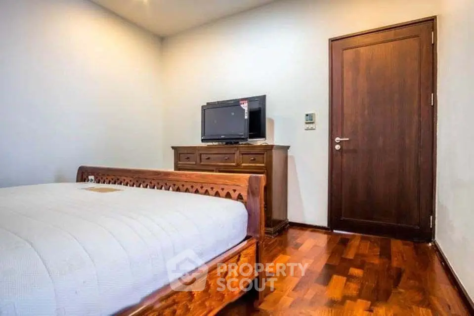 Cozy bedroom with wooden furniture and modern TV setup