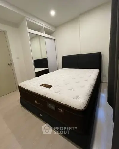 Modern bedroom with stylish bed and built-in wardrobe, perfect for cozy living.